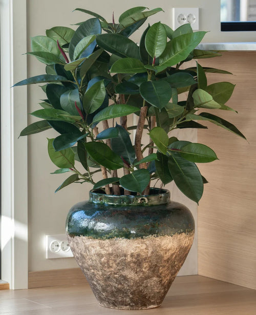 La plante artificielle Rubber Deluxe 90 cm a de larges feuilles vertes brillantes et est présentée dans un grand pot en céramique rustique - idéal pour tous ceux qui aiment l'apparence des plantes à caoutchouc sans avoir besoin d'entretien.