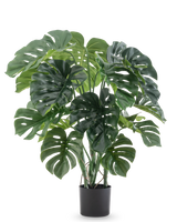 De Kunstplant Monstera 90 cm heeft grote, gespleten groene bladeren en wordt geleverd in een zwarte pot, tegen een effen witte achtergrond.