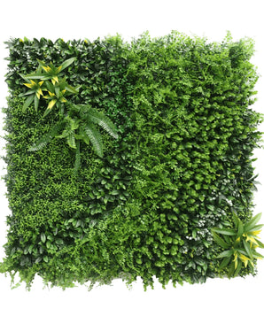 De Kunsthaag Crush 100x100 cm UV is een vierkant paneel dat dicht bedekt is met verschillende kunstgroene planten en bladeren, met geel getipt gebladerte in twee hoeken voor een weelderige verticale tuinlook.