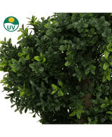 Gros plan des feuilles denses et vertes du Buxus artificiel spirale style romain UV 90 cm, avec une petite icône UV verte dans le coin supérieur gauche avec un soleil et les lettres UV.