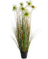De Kunstgras chrysant uienpot 90cm brandvertragend is een kunstplant in pot met hoge groene en bruine grasachtige bladeren, witte chrysantenbloemen bovenop en wordt geleverd in een kleine zwarte pot.