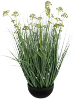 De Kunstgras Prei Bloem Ui Graspot 60cm brandvertragend heeft lange, dunne groene bladeren en lange stelen met geelgroene bloemtrossen in een zwarte pot, afgebeeld op een witte achtergrond.